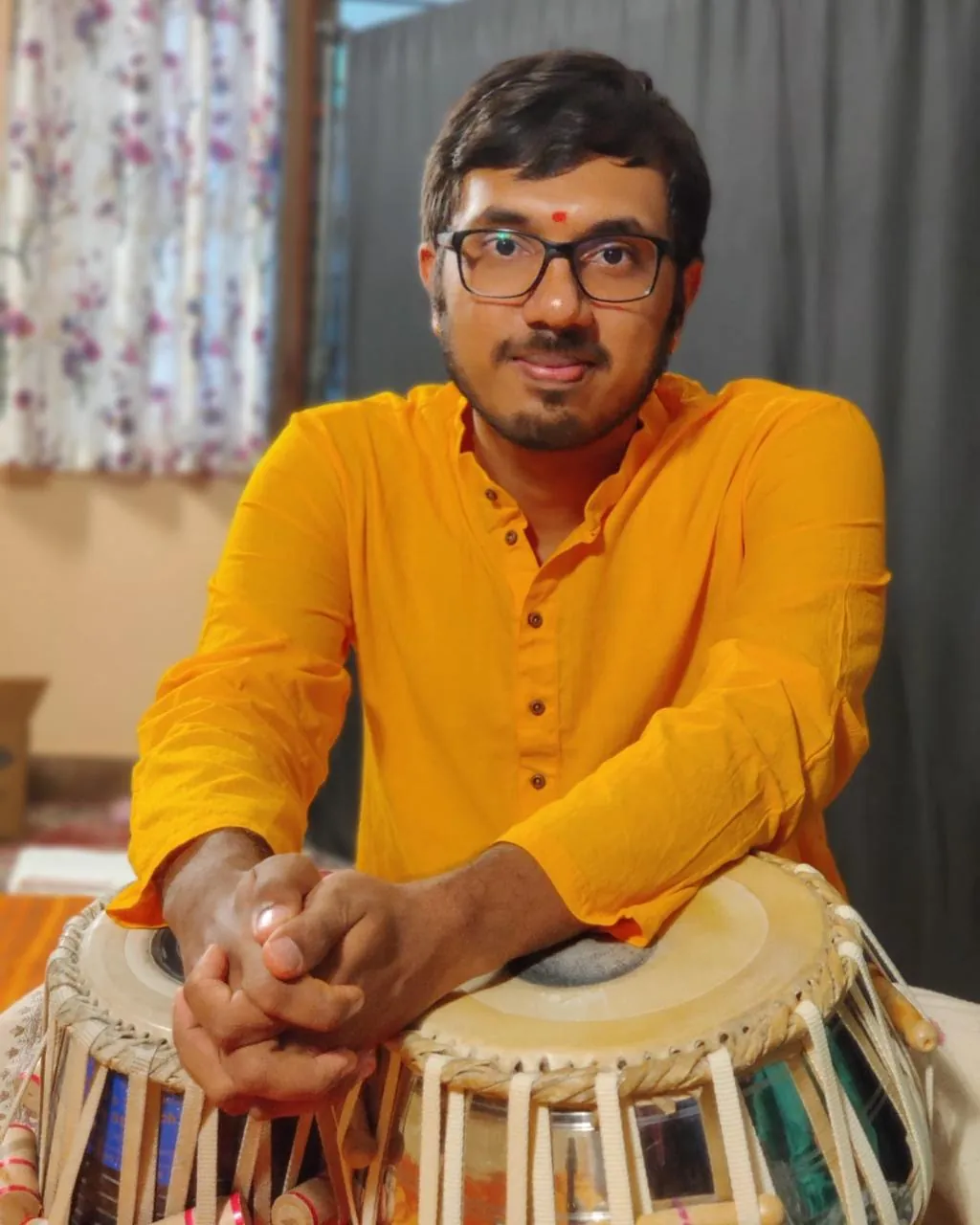 Portrait of tabla artist Kaushik Bhat resting on his tabla