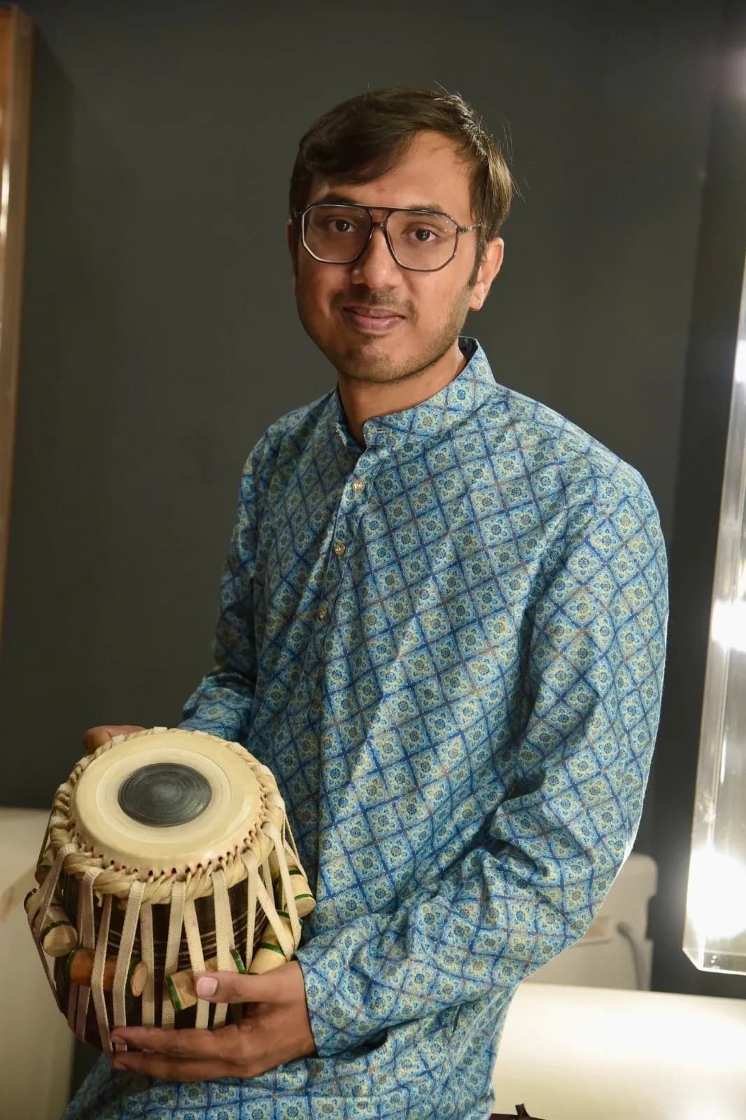 Tabla teacher Kaushik Bhat holding a dayan tabla drum in Bangalore